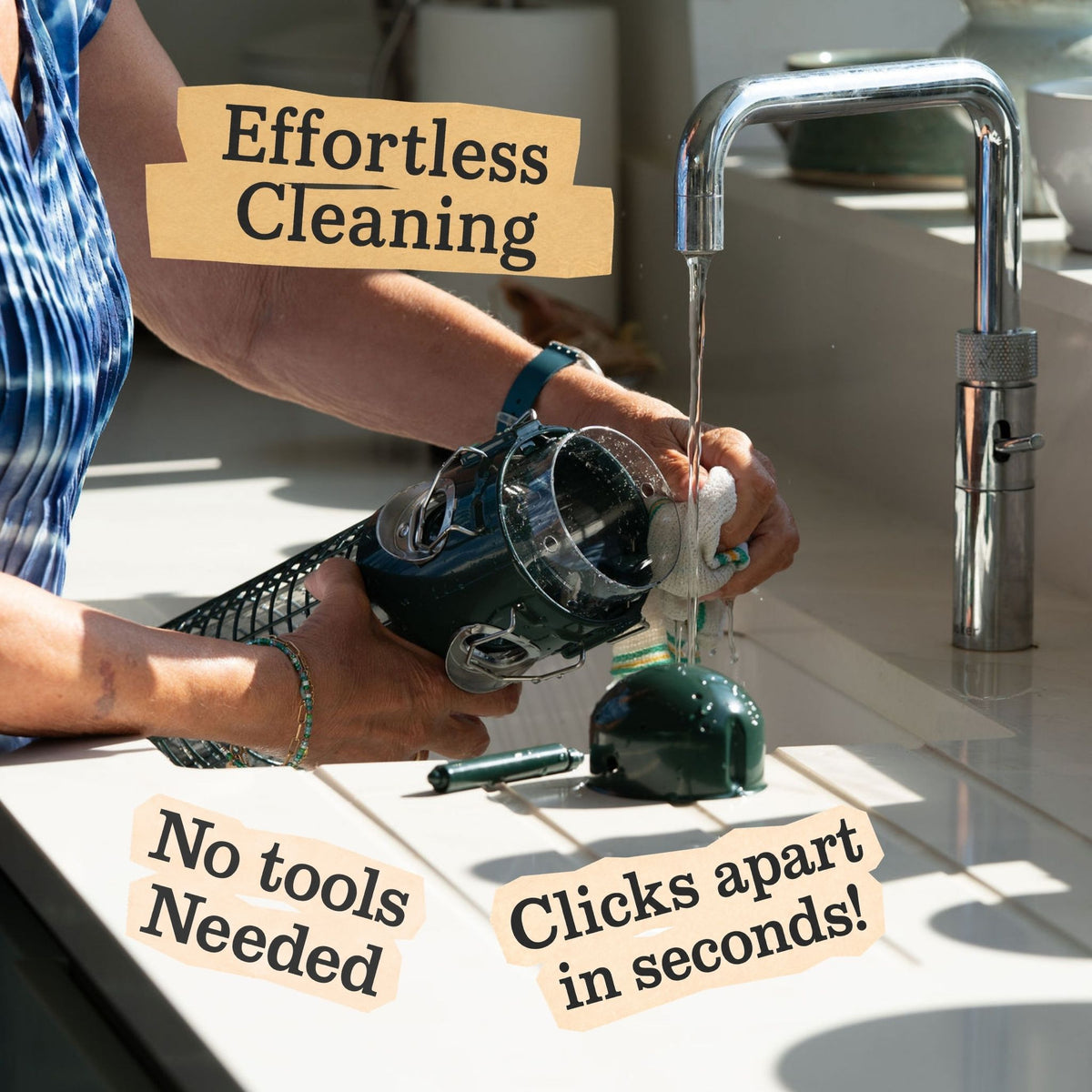 Sky-Tube bird feeder being cleaned under a tap, with tool-free, easy-clean parts.
